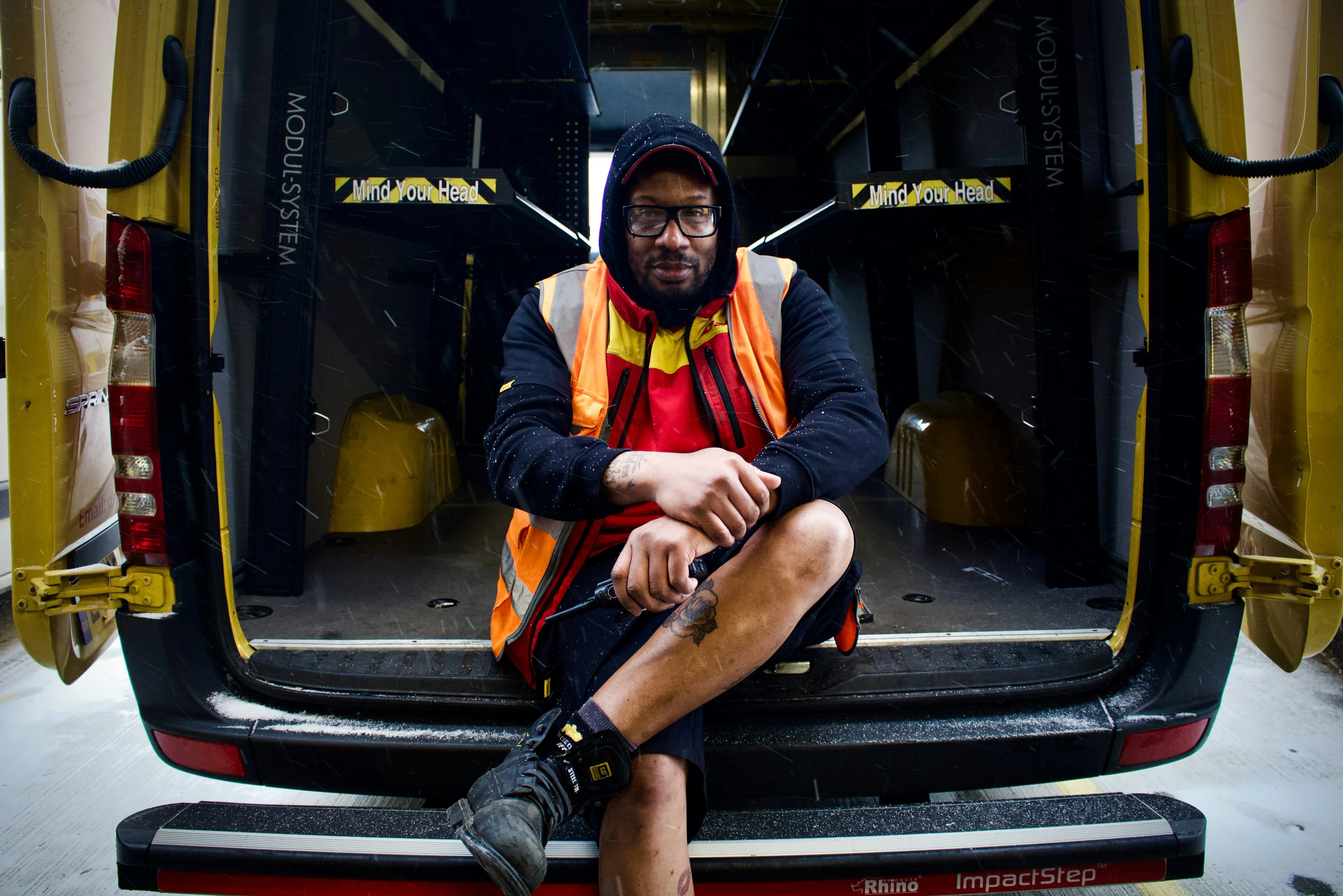 Field-service technician sitting in the back of a work van